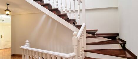 A wooden staircase with white balusters and a white handrail.