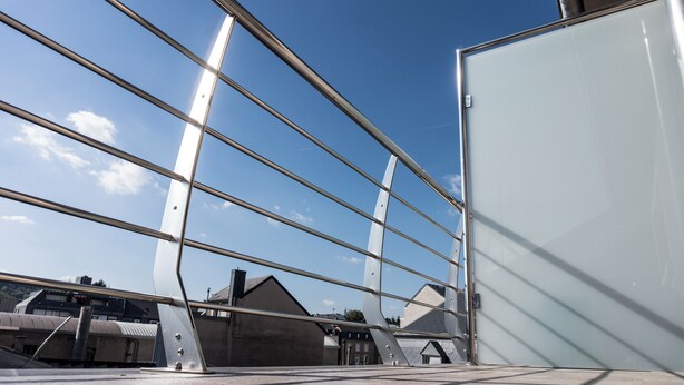 Un edificio moderno con fachada de vidrio y estructura metálica.
