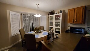 A dining area with a table, chairs, a chandelier, and a cabinet with glass doors. - For a professional Room in NW Calgary (Calgary)
