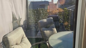 A balcony with outdoor furniture, including two chairs and a table. - For a professional Room in NW Calgary (Calgary)