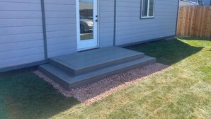 A single-story house with a front door, a small window, and a set of steps leading to the door. - Unique container home  (El Cajon)