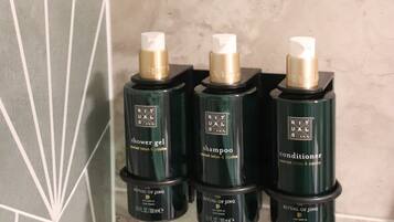 Three bottles of Ritual of Jing products on a tiled wall.