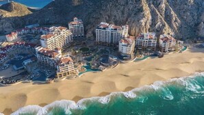 Un hôtel situé sur la côte, composé de plusieurs bâtiments, avec une plage et une falaise rocheuse.
