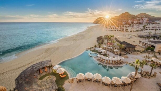 Un complexe hôtelier doté d’une piscine, d’une plage et offrant une vue sur les montagnes.