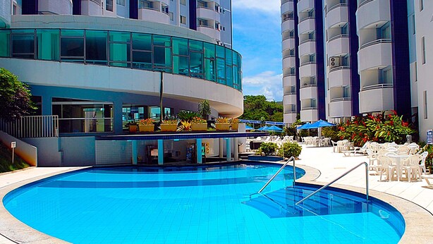 Un hotel moderno con piscina, zona de estar al aire libre y jardín ajardinado.