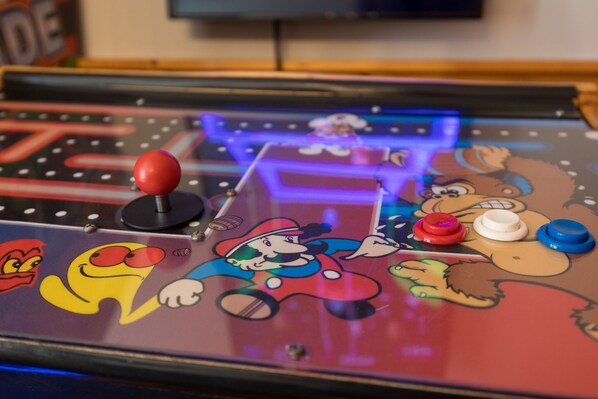 A close-up of a pinball machine with colorful characters and buttons. - Stylish Family Cabin • 4BR, Hot Tub, Arcades • Near Dollywood (Pigeon Forge)