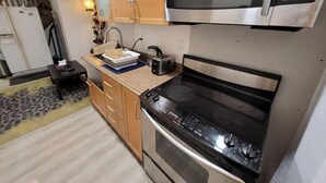 A compact kitchen with a microwave, oven, and toaster. - Elegant Modern 1 Bedroom Apt in Toronto North York (Toronto)