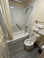 Bañera con ducha, toallas, jabón, shampoo