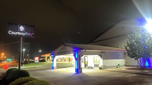 A gas station with a sign reading "CourtesyStay" and a covered parking area. - CourtesyStay (Mansfield)