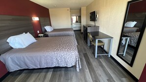 A hotel room with two beds, a desk, a chair, a television, and a mirror. - CourtesyStay (Mansfield)