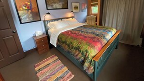 A bedroom with a bed, a nightstand, a chair, and a window with curtains. - Cozy 1-bedroom stand alone apartment in fantastic Missoula, MT.!!! (Missoula)
