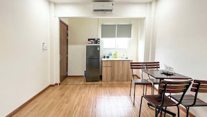 Eine kleine Küche mit Kühlschrank, Spüle und Fenster.
