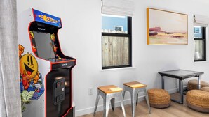 A room with a retro arcade machine, two stools, a table, and a painting on the wall. - Modern Coastal Escape - walking distance to beach! (Santa Cruz)