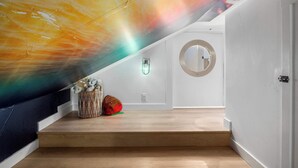 Una escalera con un espejo redondo y una lámpara de pared.
