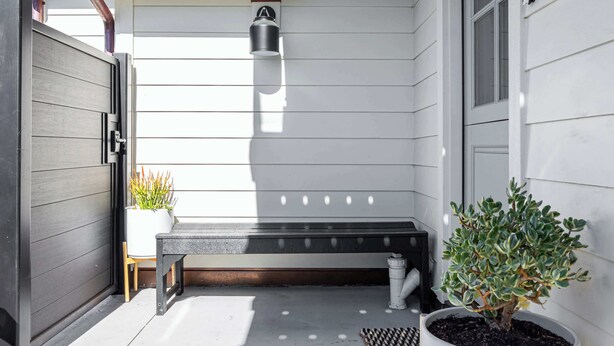 A covered outdoor area with a bench, potted plants, and a wall-mounted light fixture. - Modern Coastal Escape - walking distance to beach! (Santa Cruz)