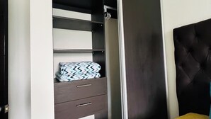 A bedroom with a bed, a wardrobe with a mirror, and a door.