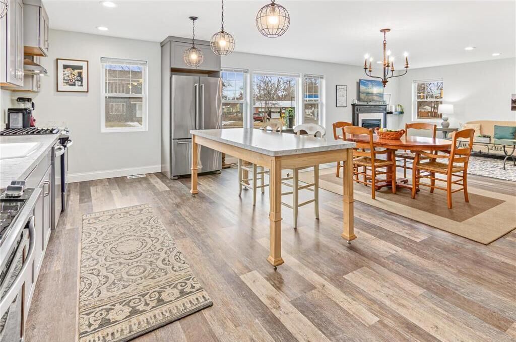 A modern kitchen with a central island, stainless steel appliances, and pendant lighting.