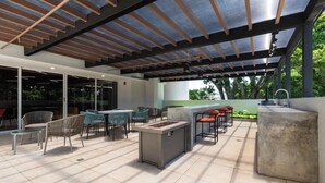 An outdoor patio with a grill, seating, and a view of the outdoors. - Cozy Apartment 10 min to Airport Be Cariari Condo new (Ulloa)