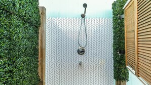 A wooden fence with a mesh wall and a showerhead. - The Prettiest Palm |Kayak, Beach Toys & Cornhole | 3mins to Beach | Community Pool | Fenced Yard (Jamaica Beach)