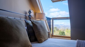 A bedroom with a bed, pillows, a lamp, and a view of the outdoors through a window. - Oakland West - Windermere, Sleeps 14 (Windermere)