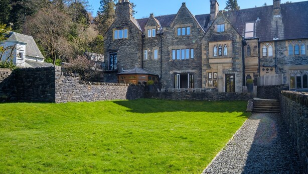 A large stone building with multiple windows and a well-maintained lawn in front. - Oakland West - Windermere, Sleeps 14 (Windermere)