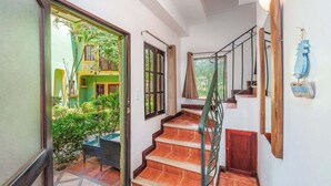 A staircase with a wooden handrail leading to a door. - Hidden Paradise LS17 -Minutes to All the Action! (Tamarindo)