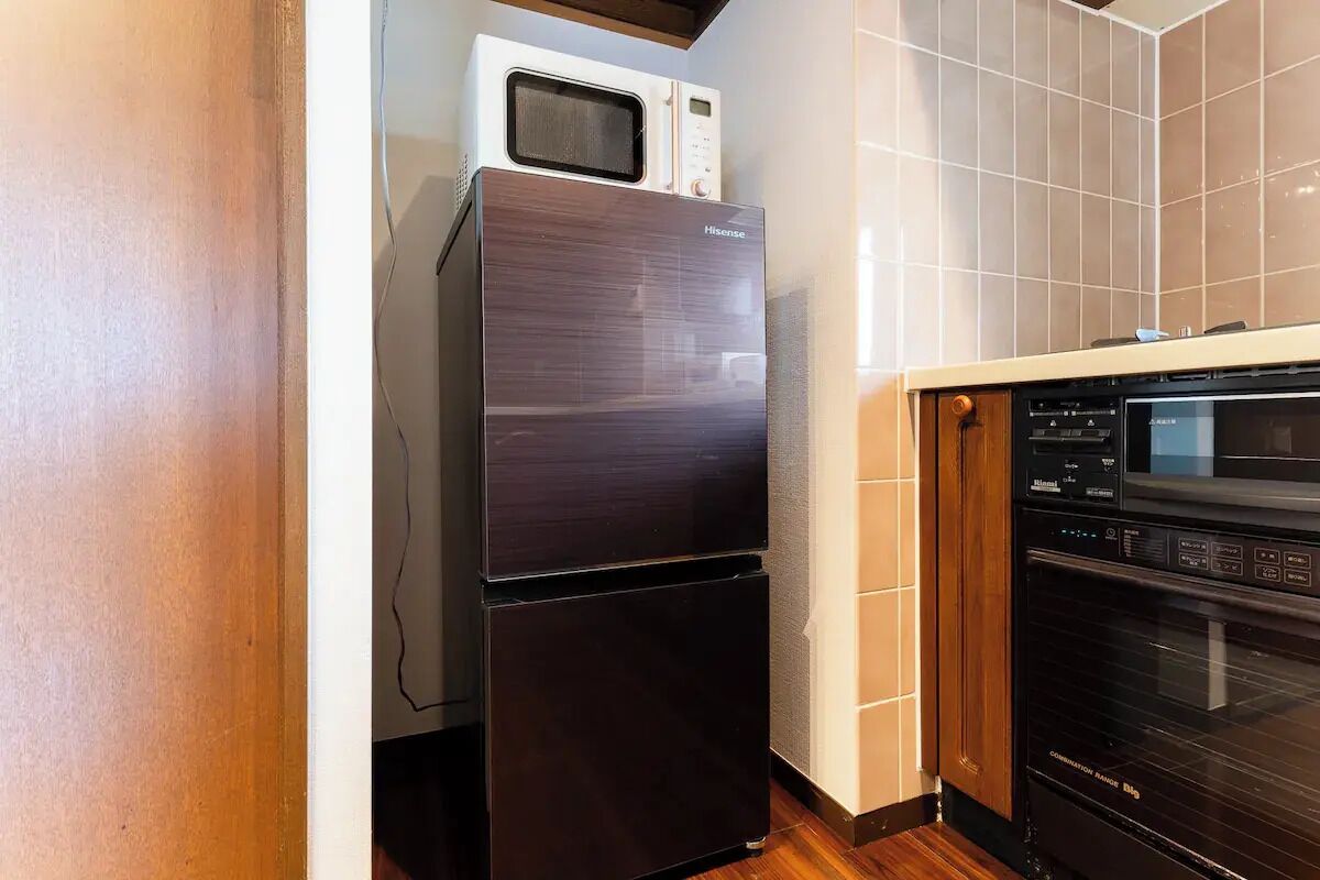 A compact kitchen with a black refrigerator, a microwave, and a dishwasher.