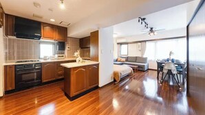 Una cucina moderna con mobili in legno, un'isola centrale e un'area pranzo con tavolo e sedie.