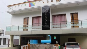 Un bâtiment à deux étages, avec une enseigne indiquant « KASA Luxury Inn » sur le niveau supérieur.