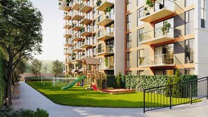 Un edificio de apartamentos moderno con balcones, un parque infantil y un jardín bien cuidado.