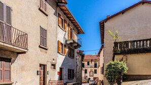 A narrow cobblestone street flanked by historic buildings with balconies and wooden shutters. - Stunning private villa for 5 people with WIFI, balcony and pets allowed (Osteno-claino)