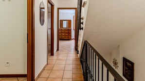 A hallway with a wooden floor, a staircase with a black railing, and a wooden dresser with a mirror. - Stunning private villa for 5 people with WIFI, balcony and pets allowed (Osteno-claino)