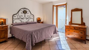 A bedroom with a bed, a dresser, a mirror, and a nightstand. - Stunning private villa for 5 people with WIFI, balcony and pets allowed (Osteno-claino)
