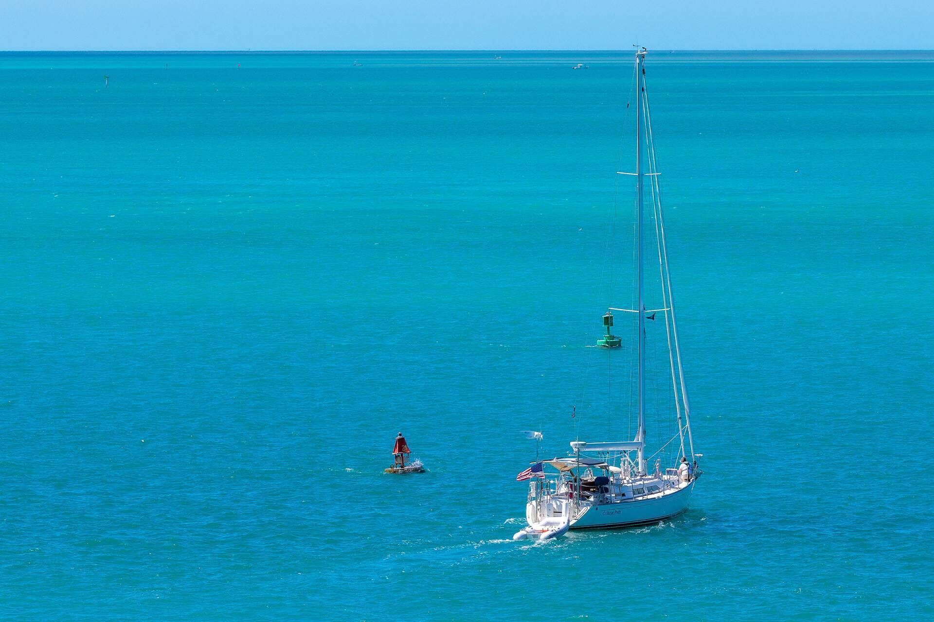 Un voilier sur une mer calme, sous un ciel dégagé.