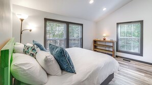 A bedroom with a large bed, two windows with blinds, a nightstand, and a floor lamp. - 2 Mi to Warm Springs Pools: Home w/ Large Yard! (Warm Springs)