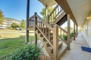 A wooden staircase leading to a covered porch with a view of a building in the background. - 3 Mi to Branson Strip: Condo w/ Golf Course View! (Branson)