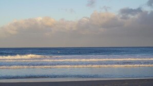 Une plage avec des vagues et un ciel dégagé.