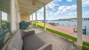 A covered outdoor area with a sofa, chairs, and a view of a lake and dock. - Catalina Lakeside Retreat: Lakefront, Dock Access, Grill, Views, and Near Hot Springs National Park! (Hot Springs)