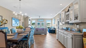 A spacious kitchen with a dining area, featuring a chandelier, a large vase, and a view of the outside. - Catalina Lakeside Retreat: Lakefront, Dock Access, Grill, Views, and Near Hot Springs National Park! (Hot Springs)