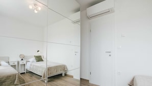 A modern bedroom with two beds, a wardrobe, and a mirror. - Spacious Luxury Trogir Apartments (Trogir)