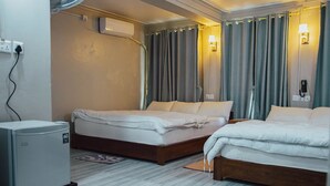 Ein Hotelzimmer mit zwei Betten, einem Heizkörper, einem Telefon und einer Lampe.
