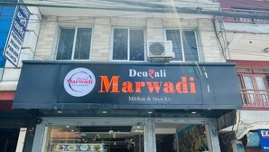 Ein Geschäft mit einem Schild für "Devari Marwadi", das Mithai & Snacks anbietet.