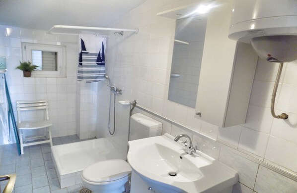 A modern bathroom with a bathtub, toilet, sink, and shower.