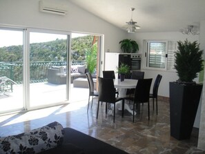 A modern kitchen with a dining area, a balcony with a view, and a potted plant. - Wonderful Visinisce Apartments With Terrace and Sea Views (Marina)