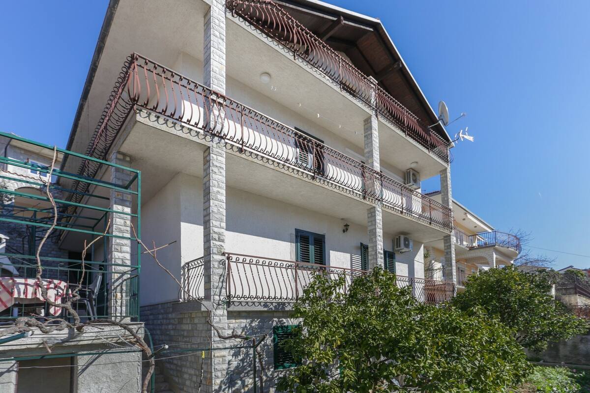 A multi-story building with balconies, a satellite dish, and a satellite on the roof.
