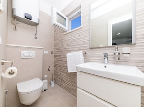 Une salle de bain moderne équipée de toilettes, d’un bidet et d’un lavabo.