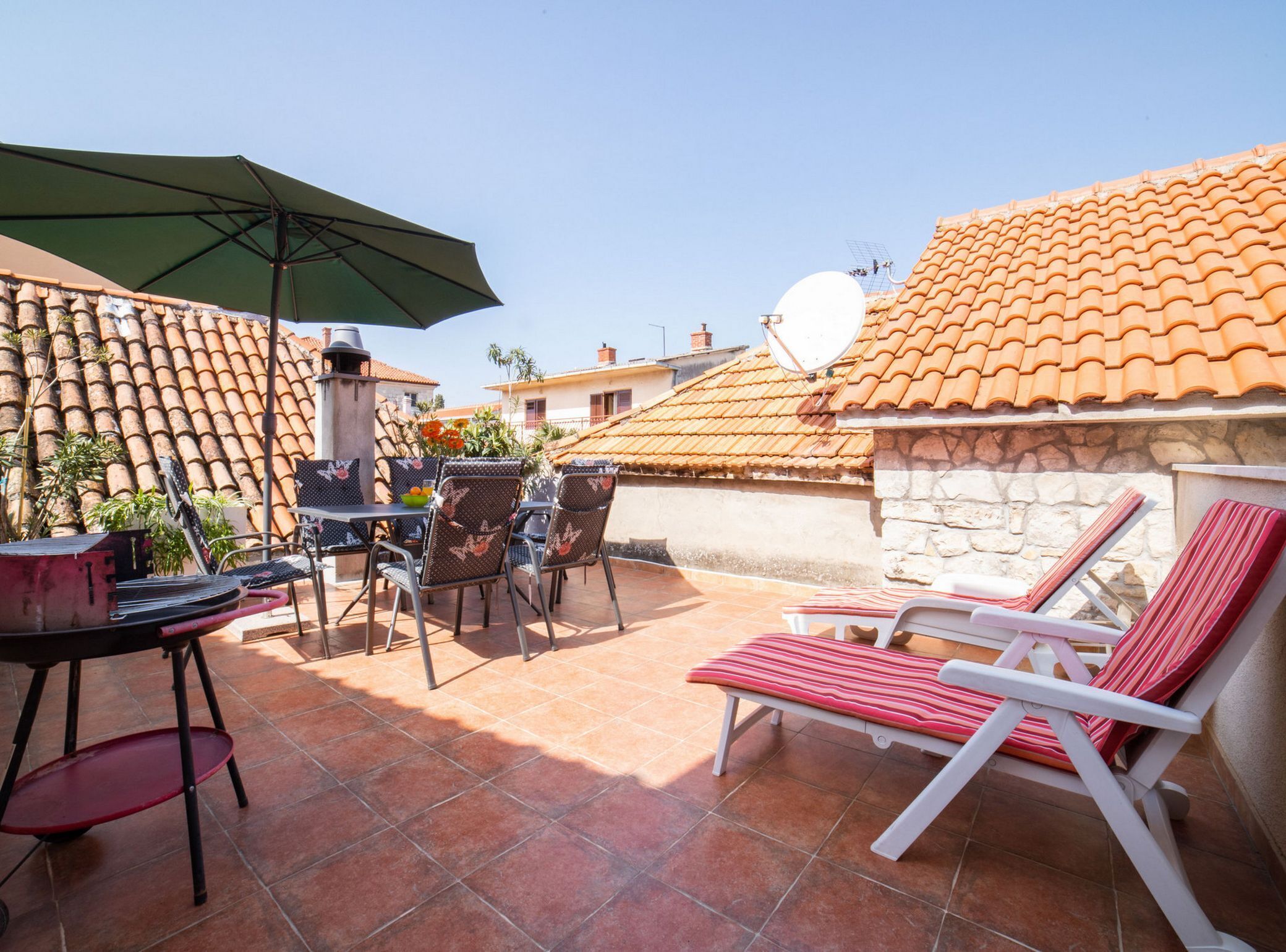 A patio with outdoor furniture, a satellite dish, and a stone wall.