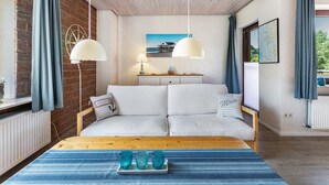 A bedroom with a bed, a wooden table, a dresser, a lamp, and a window with curtains. - Apartment 'Gode Tied' with Private Terrace, Balcony and Wi-Fi (Wesseln)