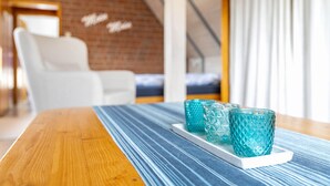A wooden table with a blue striped table runner and three turquoise glass cups on a white tray. - Apartment 'Gode Tied' with Private Terrace, Balcony and Wi-Fi (Wesseln)