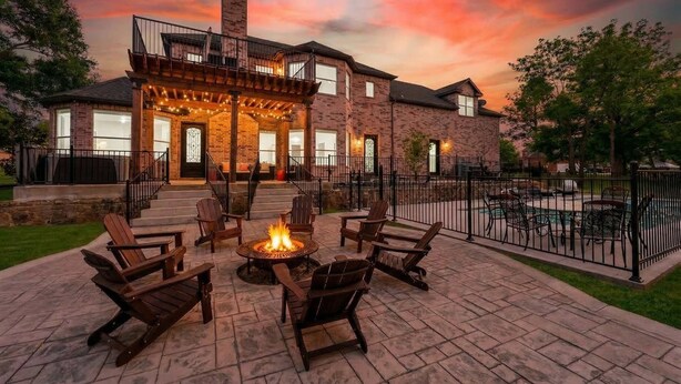 A brick house with a covered patio, outdoor seating, and a fire pit. - The Cove: Heated Pool, Hot Tub, Lake Access (Shady Shores)